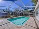 Inviting private pool enclosed by a screened-in enclosure and stone patio, perfect for outdoor enjoyment at 8600 Berkley Dr, Hudson, FL 34667
