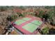 Aerial view of two fenced tennis courts with lush trees surrounding the complex in a residential area at 8600 Berkley Dr, Hudson, FL 34667
