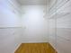 Spacious walk-in closet with white wire shelving and light wood-look floors at 8600 Berkley Dr, Hudson, FL 34667