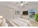 Bright bedroom with a ceiling fan, TV, white dresser, and double door closet at 9324 Agate St, Port Charlotte, FL 33981