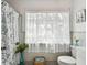 Cozy bathroom with decorative shower curtain, and an expansive window at 11124 Corlett Rd, Riverview, FL 33578