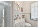 Cozy bathroom features a white sink and toilet, complemented by a decorative round mirror at 11124 Corlett Rd, Riverview, FL 33578