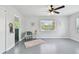 Bedroom with gray floors, ceiling fan, and view into blue-tiled bathroom at 11124 Corlett Rd, Riverview, FL 33578