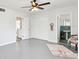 Bedroom with gray floors, bathroom access, ceiling fan, and decoratives at 11124 Corlett Rd, Riverview, FL 33578