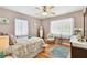 Cozy bedroom featuring hardwood floors, floral bedding, bright natural light, and ample space at 11124 Corlett Rd, Riverview, FL 33578