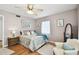 Comfortable bedroom with hardwood floors, patterned bedding, bright natural light, and ample storage space at 11124 Corlett Rd, Riverview, FL 33578