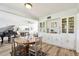 View of the dining room featuring a built-in China cabinet, a grand piano, and hardwood flooring at 11124 Corlett Rd, Riverview, FL 33578