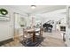 Cozy dining area with a table set for four, and an open view to the living area and grand piano at 11124 Corlett Rd, Riverview, FL 33578