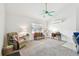 Bright living room with neutral carpet, white walls, ceiling fan, window, and comfortable seating arrangements at 11124 Corlett Rd, Riverview, FL 33578