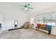 Bright main bedroom with neutral carpet, white walls, ceiling fan, and comfortable seating arrangements at 11124 Corlett Rd, Riverview, FL 33578