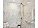 Accessible shower with white marble-style tiles, grab bars, shower chair, and sleek shower fixtures at 11124 Corlett Rd, Riverview, FL 33578