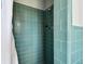 A tiled shower stall featuring green tile and shower head at 11124 Corlett Rd, Riverview, FL 33578
