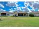 Back view of the property featuring a well-manicured lawn and screened lanais, perfect for enjoying the outdoors at 1168 Emerald Hill Way, Valrico, FL 33594