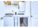 A bright laundry room featuring white appliances, wire shelving, and white doors at 1168 Emerald Hill Way, Valrico, FL 33594