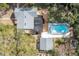 Aerial view of the home with a pool, a deck, a detached garage, and mature trees at 1209 E Idlewild Ave, Tampa, FL 33604