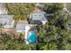 Aerial view of the property showcasing the backyard pool, deck, and overall layout amidst lush greenery at 1209 E Idlewild Ave, Tampa, FL 33604