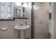 Bathroom featuring white tiling, updated pedestal sink, and framed glass shower at 1209 E Idlewild Ave, Tampa, FL 33604