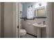 Bright bathroom with a pedestal sink, framed mirror, and patterned tile flooring at 1209 E Idlewild Ave, Tampa, FL 33604