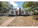 Charming home with a red front door, brick chimney, and professionally landscaped front yard at 1209 E Idlewild Ave, Tampa, FL 33604