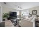 Comfortable living room features tile floors, white sofas, and a large television at 1209 E Idlewild Ave, Tampa, FL 33604