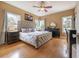 Bright main bedroom with hardwood floors, tufted headboard, and natural light from multiple windows at 1209 E Idlewild Ave, Tampa, FL 33604