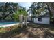 Backyard featuring a pool with a surrounding fence, a shed and mature landscaping at 1209 E Idlewild Ave, Tampa, FL 33604