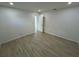 Minimalist bedroom with wood-look tile floors, a white door, and an open doorway leading to another room at 1324 51St Ne Ave, St Petersburg, FL 33703