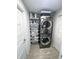 Compact laundry area featuring a stacked washer and dryer, shelving, and ample storage space at 1324 51St Ne Ave, St Petersburg, FL 33703