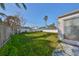 A backyard featuring green grass, a privacy fence and bright sunshine at 15548 1St E St, Redington Beach, FL 33708