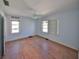 Bedroom with hardwood floors, a ceiling fan, two windows with blinds and light blue walls at 15548 1St E St, Redington Beach, FL 33708