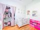 Cozy Bedroom featuring a crib, closet, and pink storage bins, ideal for a baby's room at 1609 Shady Oaks Dr, Oldsmar, FL 34677