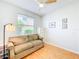 Well-lit bedroom featuring a ceiling fan, wood floors, a comfortable sofa, and stylish decor at 1609 Shady Oaks Dr, Oldsmar, FL 34677