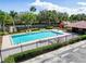 Community pool surrounded by lounge chairs, greenery, a playground, and a cabana at 1609 Shady Oaks Dr, Oldsmar, FL 34677