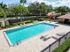 Community pool with sun loungers, a playground, and manicured landscaping for relaxation at 1609 Shady Oaks Dr, Oldsmar, FL 34677