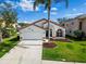 Charming single-story home featuring a well-manicured lawn, a two-car garage, and eye-catching white and orange trim at 1609 Shady Oaks Dr, Oldsmar, FL 34677