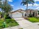 Charming single-story home featuring a well-manicured lawn, a two-car garage, and eye-catching white and orange trim at 1609 Shady Oaks Dr, Oldsmar, FL 34677