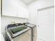 Modern laundry room with a stainless steel washer and dryer and white cabinets for storage at 1609 Shady Oaks Dr, Oldsmar, FL 34677