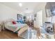 Bright bedroom featuring hardwood floors, a comfortable bed, blue leather couch and a sunny window at 18012 Melibee Stone St, Tampa, FL 33647