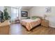 Sunlit bedroom featuring hardwood floors and a bright window providing a relaxing and comfortable living space at 18012 Melibee Stone St, Tampa, FL 33647