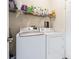 Bright laundry room featuring a full sized washer, dryer, and storage shelves at 18012 Melibee Stone St, Tampa, FL 33647