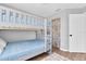 Bunk bedroom featuring a light blue color scheme, wood-look floors and a rustic sliding barn door to the closet at 219 126Th Ave, Treasure Island, FL 33706