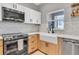 Kitchen with stainless steel appliances, wooden cabinets, and a farmhouse sink at 219 126Th Ave, Treasure Island, FL 33706