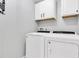 Laundry room features a side-by-side washer and dryer, with overhead storage cabinets at 219 126Th Ave, Treasure Island, FL 33706