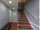 Hallway featuring a staircase with decorative tile, a bench, and neutral-colored walls at 219 126Th Ave, Treasure Island, FL 33706