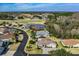 Aerial view showcases homes near a golf course and pond, blending leisure and residential living at 29307 Schinnecock Hills Ln, San Antonio, FL 33576