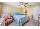 Bedroom featuring a ceiling fan, an armchair, and a view of the adjoining bathroom at 29307 Schinnecock Hills Ln, San Antonio, FL 33576