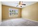 Bedroom with large window, neutral paint, plush carpet and modern ceiling fan at 29307 Schinnecock Hills Ln, San Antonio, FL 33576