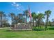 Sign for Tampa Bay Golf & Country Club welcomes with palm trees and colorful flower beds at 29307 Schinnecock Hills Ln, San Antonio, FL 33576