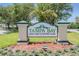 Welcoming sign for Tampa Bay Golf and Country Club amidst lush landscaping and blue flowers at 29307 Schinnecock Hills Ln, San Antonio, FL 33576