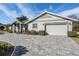 Front exterior featuring a paved driveway, well-maintained landscaping, and an attached garage at 29307 Schinnecock Hills Ln, San Antonio, FL 33576